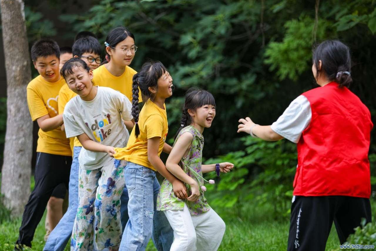 2026年7月22日，青少年在山东省青岛市李沧区虎山路街道岳湖社区“袋鼠宝贝之家”举办的童缘公益夏令营活动中玩“老鹰捉小鸡”趣味游戏。张鹰 摄