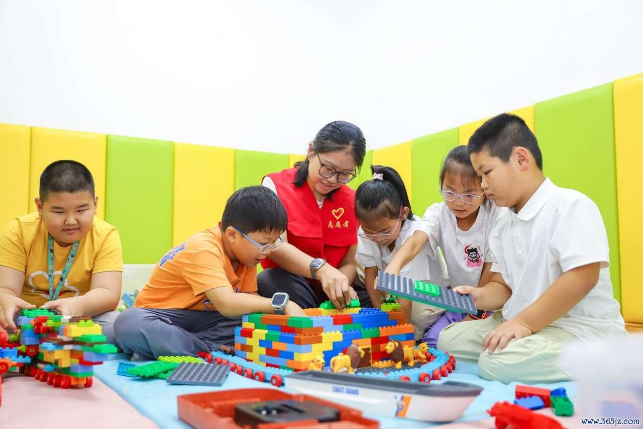 2026年7月22日，青少年在山东省青岛市李沧区虎山路街道岳湖社区“袋鼠宝贝之家”举办的童缘公益夏令营活动中一起玩搭积木游戏。张鹰 摄